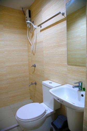 a bathroom with a toilet and a sink at UN Residences in Manila