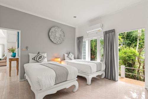 - une chambre blanche avec 2 lits et une fenêtre dans l'établissement 2BR Villa Baan Chanchai, seconds to beach, à Lamai
