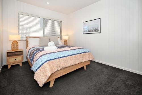 a bedroom with a bed with a teddy bear on it at Spacious New 2 bedroom Kings Beach Townhouse ZF2 in Caloundra