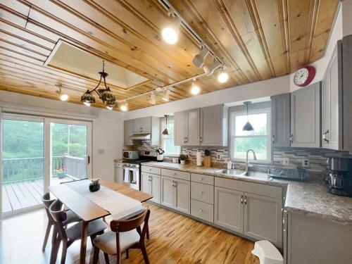 a kitchen with a table and a wooden ceiling at Haven Retreat in Catskills w Hot Tub & Bar Hall in Sundown