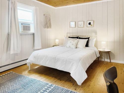 a white bedroom with a large bed and a window at Haven Retreat in Catskills w Hot Tub & Bar Hall in Sundown