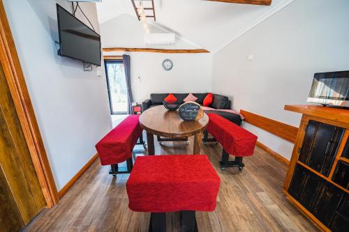 a living room with a table and chairs and a tv at Wallabies, parrots, farm animals in St Helens