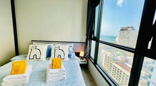 a bedroom with a bed and a large window at BASE Central PATTAYA Quiet King-Bed with Infinity Pool & Free Netflix in Pattaya Central