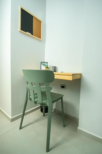 a green chair sitting in front of a desk at Barcelo Coliving in Medellín