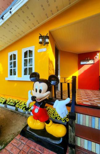 a mickey mouse toy in front of a house at Apinya Resort Bangsarey in Ban Tao Than