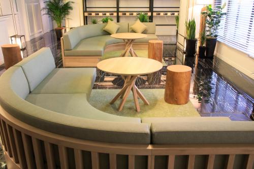 a lobby with two tables and a couch at QuintessaHotel KagoshimaTenmonkan Relax&Sleep in Kagoshima