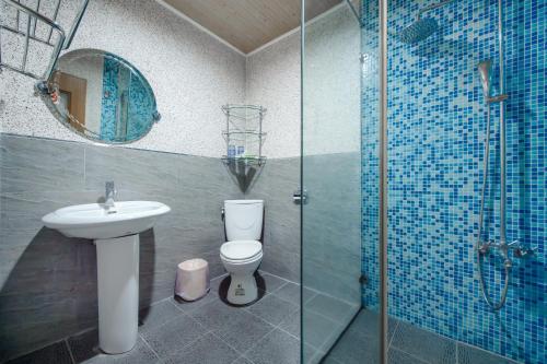 a bathroom with a toilet and a sink and a shower at Bishui Shanju Lakeside B&B in Yuchi