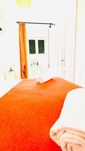 a bed with an orange blanket on top of it at Villa La Zagara by CapriRooms in Capri
