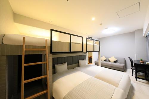 a bedroom with a bunk bed and a couch at QuintessaHotel KagoshimaTenmonkan Relax&Sleep in Kagoshima