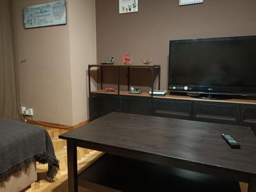 een woonkamer met een televisie en een salontafel bij El Hogar de Todos in Ourense