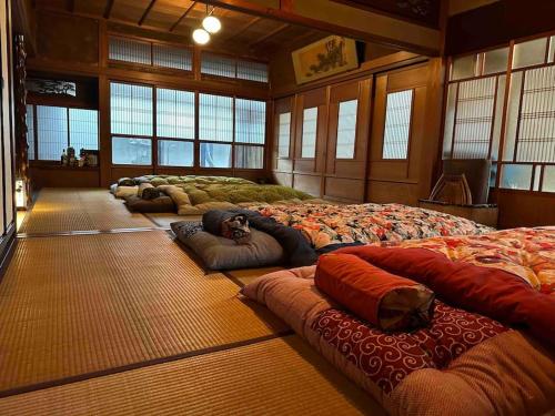 una habitación con un montón de camas en el suelo en Old Japanese House, en Tondabayashi