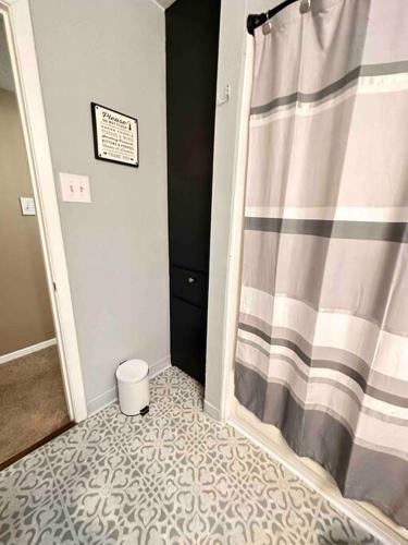 a bathroom with a shower with a shower curtain at Short Walk to JSU Stadium, Hospitals, and Bars in Fondren in Jackson