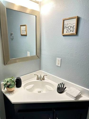 a bathroom with a sink and a mirror at Short Walk to JSU Stadium, Hospitals, and Bars in Fondren in Jackson