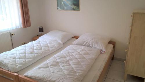 2 nebeneinander sitzende Betten in einem Schlafzimmer in der Unterkunft Leichtmatrose in Dorum Neufeld