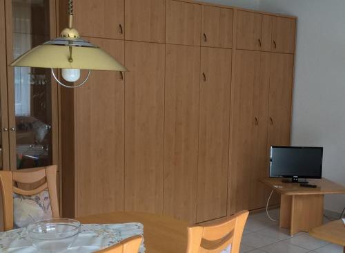 ein Wohnzimmer mit einem Tisch und einem TV in der Unterkunft Leichtmatrose in Dorum Neufeld