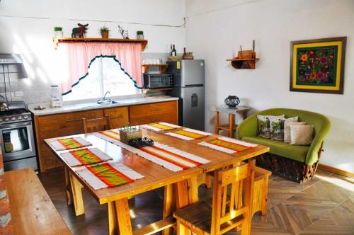 a kitchen with a wooden table and a dining room at Hermosa y cálida casa tipo cabaña in Creel
