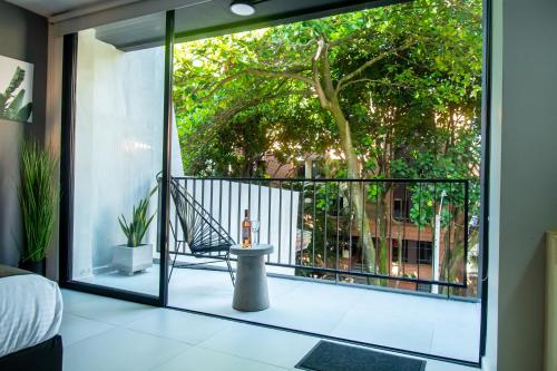 a room with a balcony with a chair and a window at Barcelo Coliving in Medellín