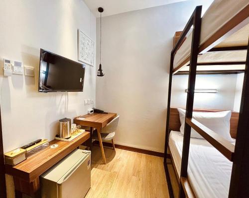 Zimmer mit einem Schreibtisch und einem Etagenbett in der Unterkunft oxy suites G-03 at Shop House Meisterstadt Pollux Habibie in Batam Center