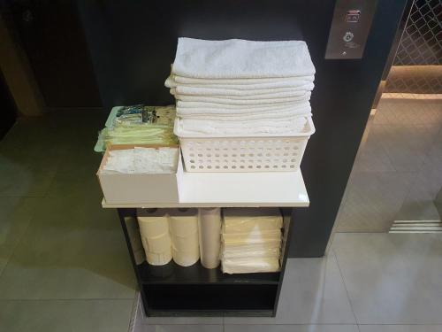 einen Stapel Handtücher auf einem Regal in einem Schrank in der Unterkunft Hotel Daisy in Seoul