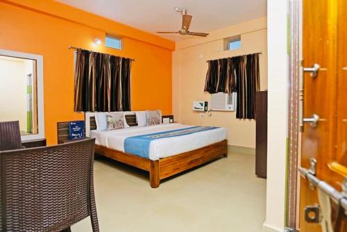 a bedroom with a bed with an orange wall at Krishna Residency ! Puri in Puri