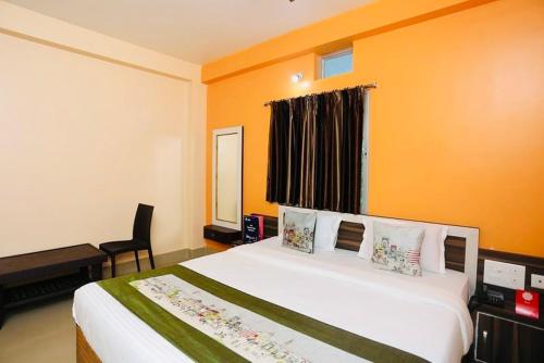 a bedroom with a bed and a chair and a window at Krishna Residency ! Puri in Puri