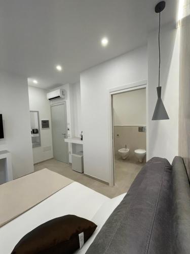 a white room with a bed and a bathroom at Bullerjanos in Olbia