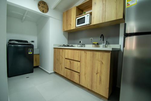 a kitchen with wooden cabinets and a stainless steel refrigerator at Barcelo Coliving in Medellín