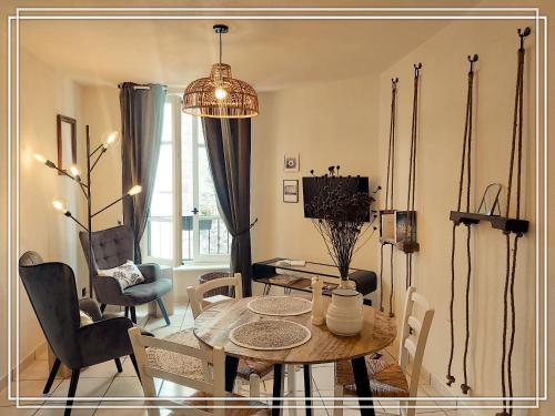 sala de estar con mesa y sillas en APPART HOTEL Place des Jolis Rêves en Riom-ès-Montagnes