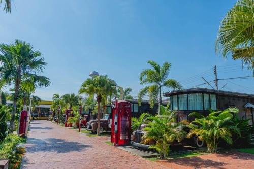a row of old red phone booths and palm trees at Apinya Resort Bangsarey in Ban Tao Than