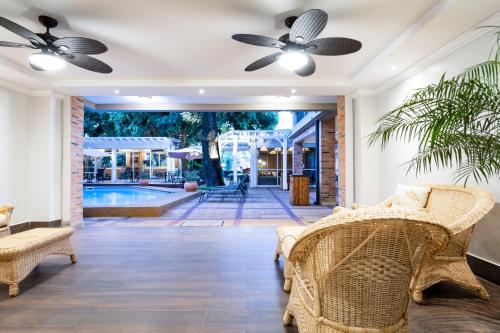a living room with wicker furniture and a pool at Hotel Villa Morra Suites in Asuncion