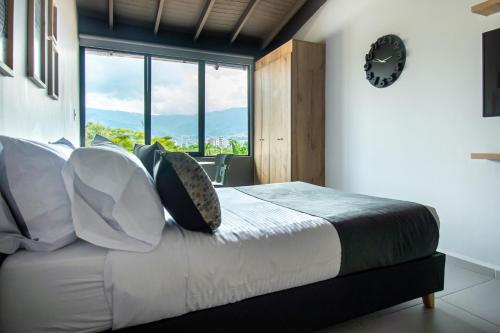 a bedroom with a bed with pillows and a window at Barcelo Coliving in Medellín