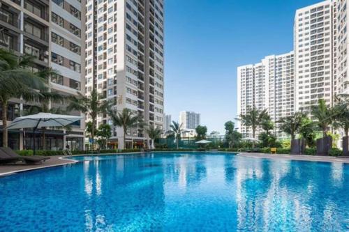 een groot zwembad in het midden van twee hoge gebouwen bij Shin's Conner- 1 bedroom apartment 50m2 at Vinhomes Ocean Park in Hanoi