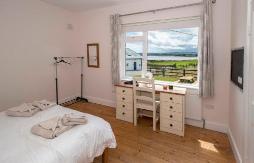 - une chambre avec un lit, un bureau et une fenêtre dans l'établissement Clonea Beach Houses, à Dungarvan