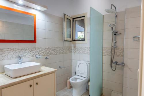 a bathroom with a toilet and a sink and a shower at Romanos Xi in Xi