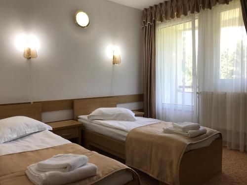 Habitación de hotel con 2 camas y ventana en Hotel Hefaistos - Sovata, en Sovata