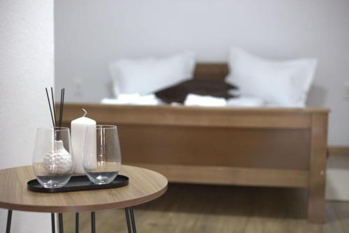a table with two glasses and a candle on it at Bingyó Vendégház in Lupeni