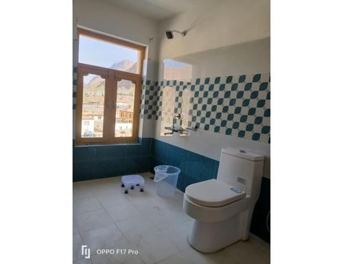 a bathroom with a toilet and a sink and a window at Hotel Himalayan Hermitage, Kaza in Kaza