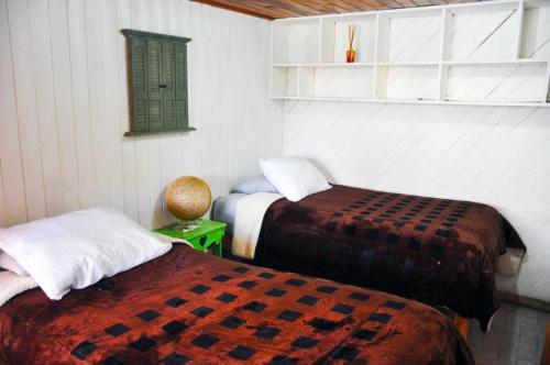 a room with two beds and a green window at Lindo Departamentito en Creel in Creel