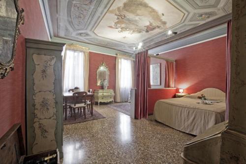a hotel room with a bed and a dining room at Palazzetto San Lio, Rialto in Venice