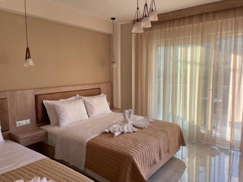 a bedroom with two beds and a window at Green Memories in Skala Sotiros