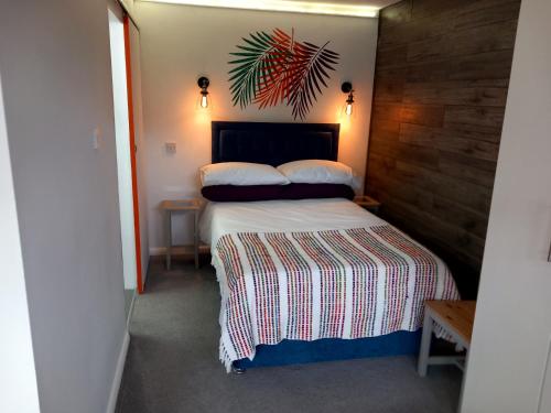 a bedroom with a bed with a wooden wall at Thistles -Private Entrance Studio 