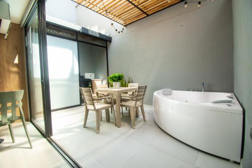 a bathroom with a tub and a table and chairs at Barcelo Coliving in Medellín