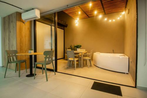 a room with a tub and a table and chairs at Barcelo Coliving in Medellín