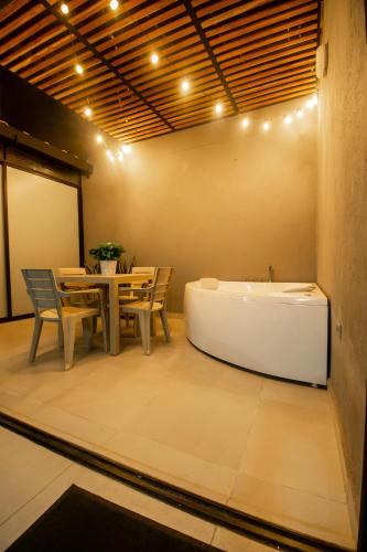 a room with a bath tub and a table with chairs at Barcelo Coliving in Medellín