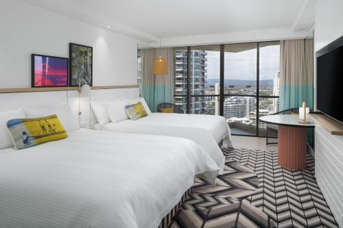 pokój hotelowy z 2 łóżkami i dużym oknem w obiekcie QT Gold Coast w mieście Gold Coast