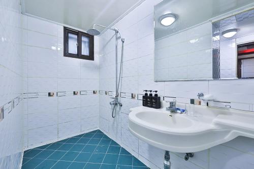 uma casa de banho branca com um lavatório e um espelho em Picasso Motel em Seul