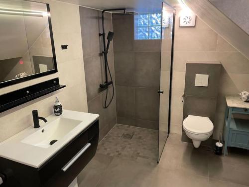 een badkamer met een douche, een wastafel en een toilet bij Nyrenoverat strandnära med fantastisk utsikt in Rimbo