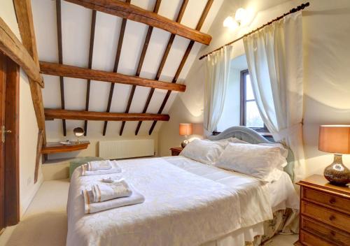 una camera da letto con un grande letto con lenzuola bianche di Beudy Uchaf a Penmaenpool