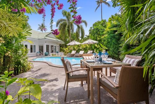 ラマイにある2BR Villa Baan Orchid, seconds to beachのプールサイドのパティオ(テーブル、椅子付)