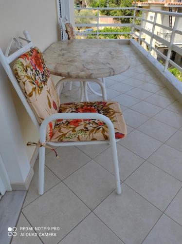a chair and a table on a balcony at Tasos Art in Káto Almirí